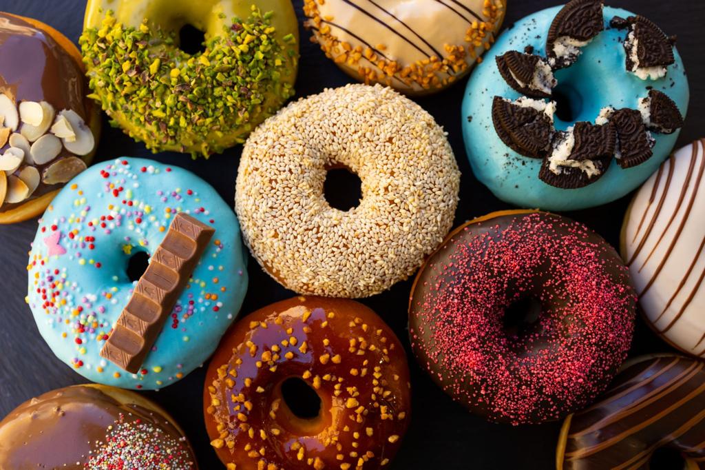 Une photo de donuts colorés et appétissants de Glazeon Le Mans, une franchise française spécialisée dans les donuts artisanaux, les bagels, le café et le bubble tea.