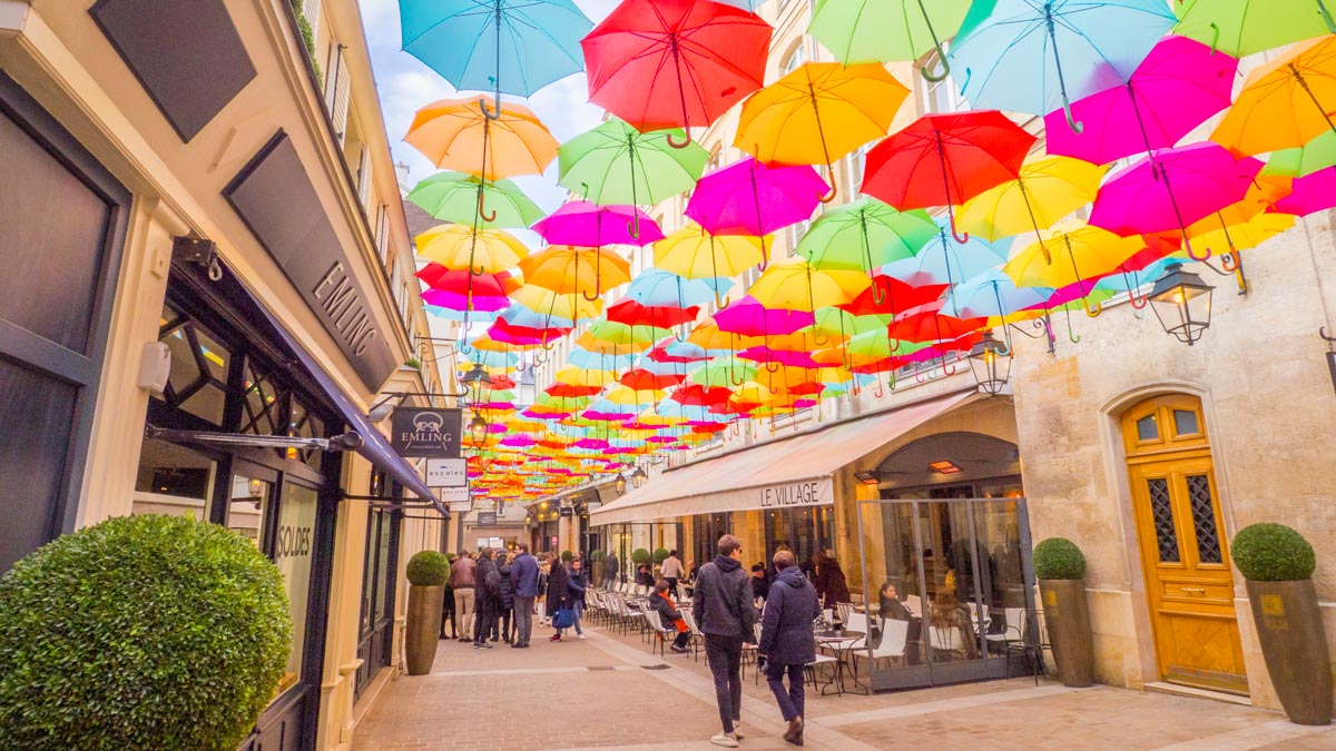 Découvrez un arc-en-ciel de 800 parapluies suspendus au Village Royale à Paris !