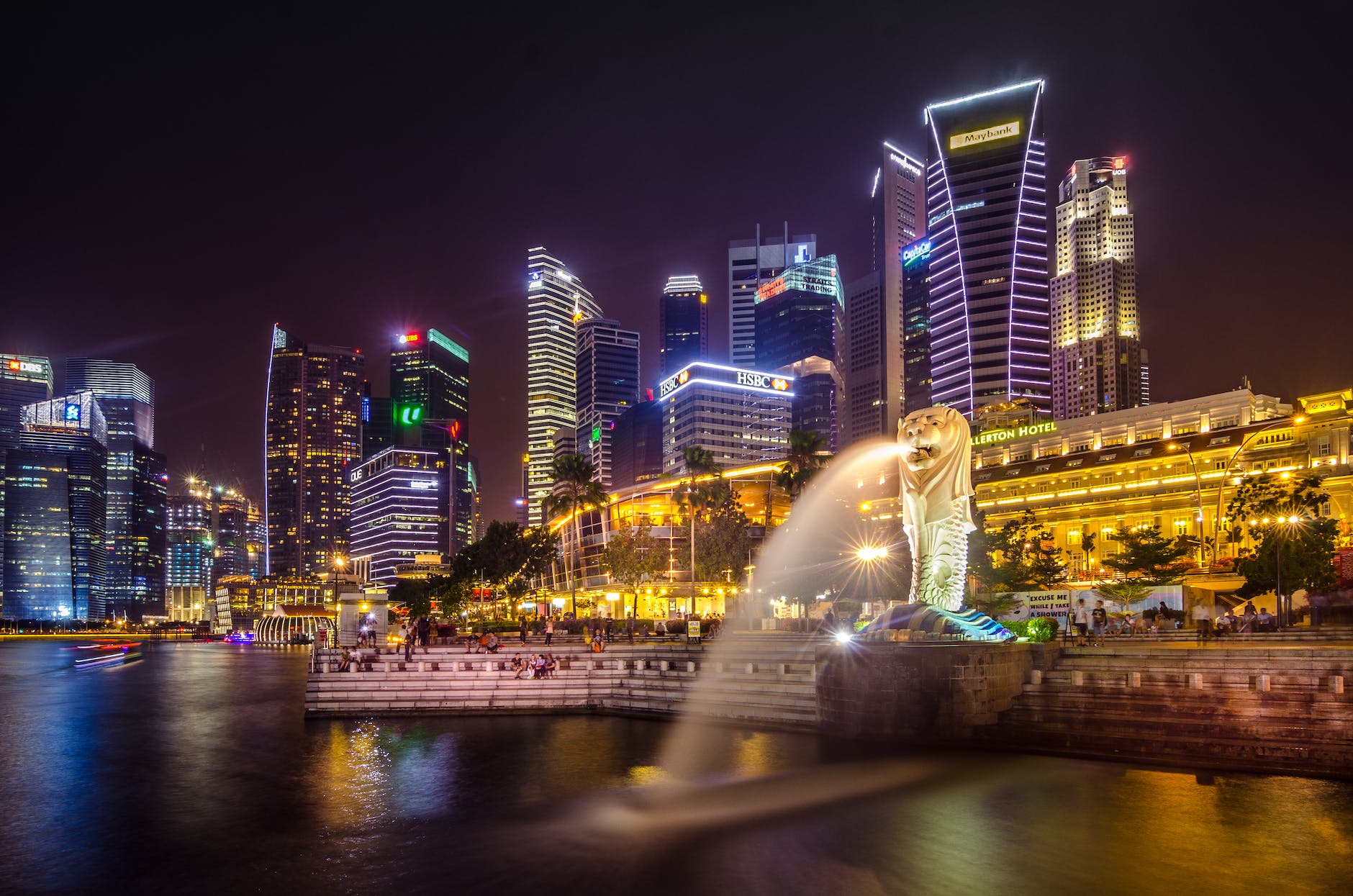 Paysage urbain nocturne du centre-ville de Singapour, illuminé par les lumières scintillantes des gratte-ciels.